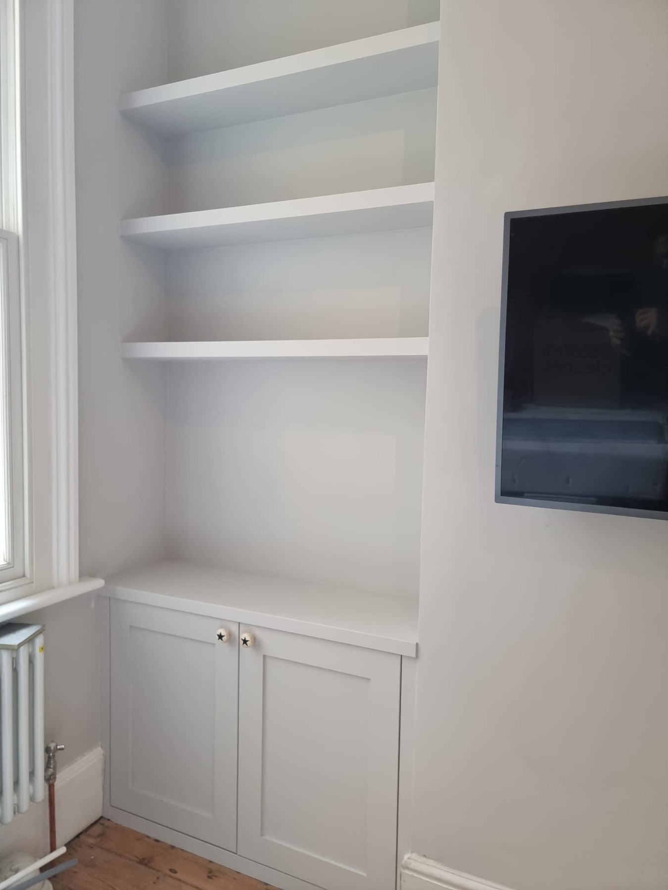 Alcove unit with floating shelves above a base cupboard
