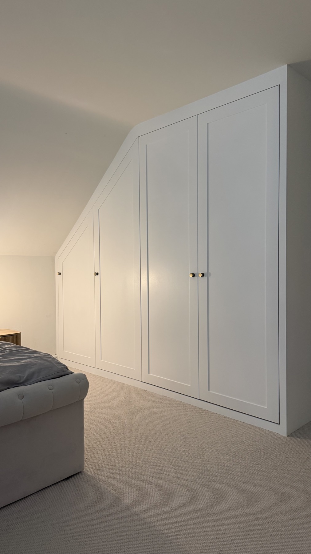 Fitted wardrobes under a sloping attic ceiling