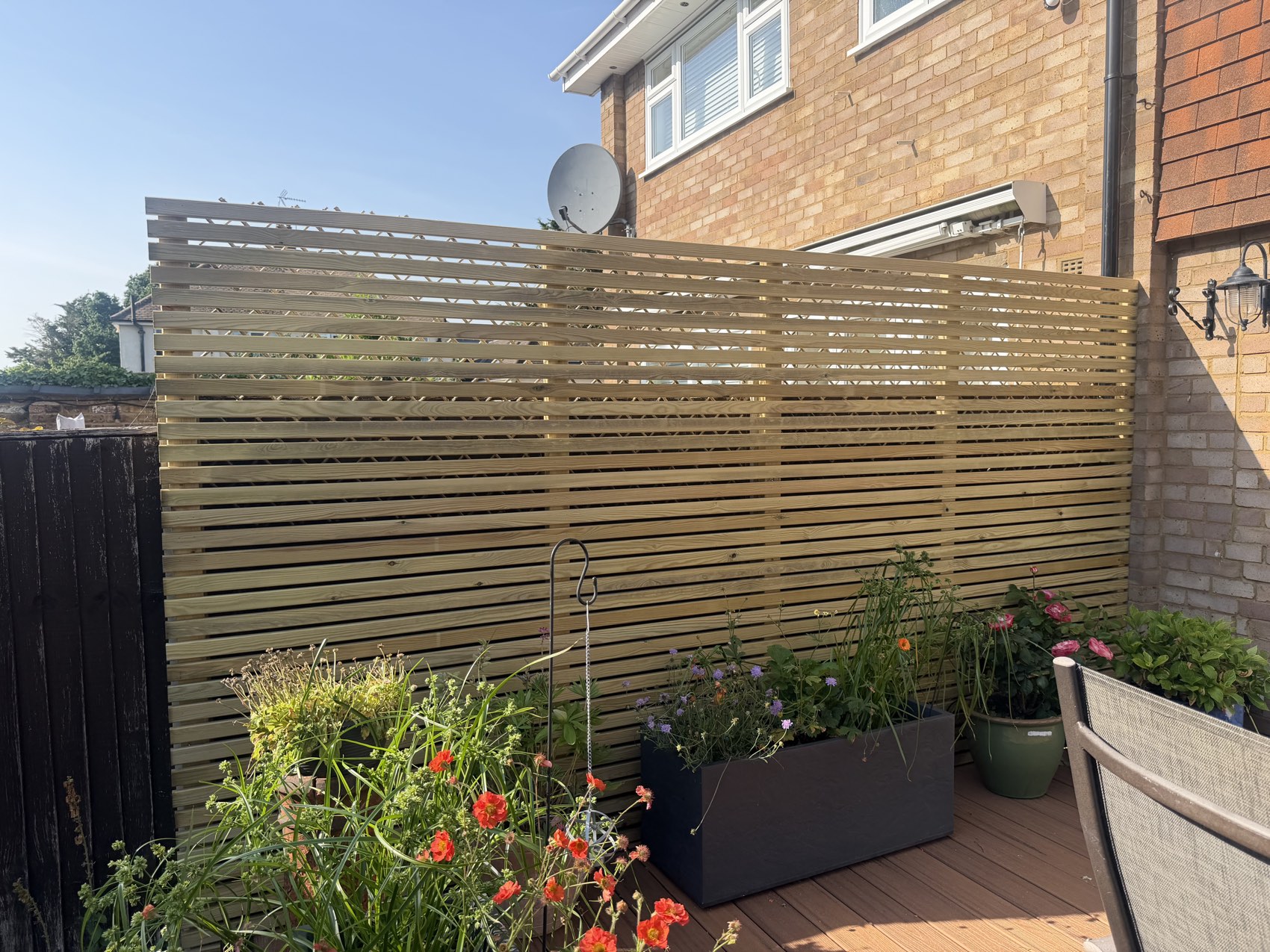Slatted timber privacy screen fence on a decked patio