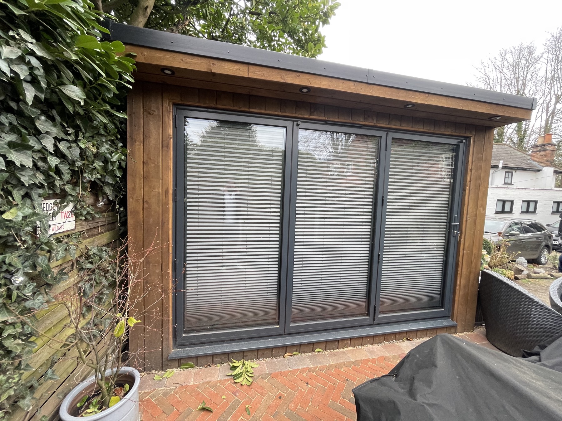 Timber garden room with a projecting canopy over anthracite doors