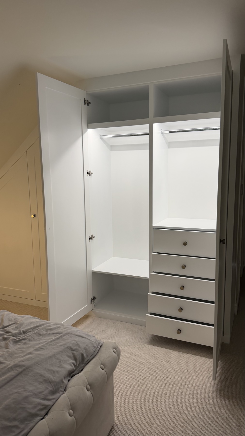 Inside the angled attic wardrobe: LED-lit rails and internal drawers