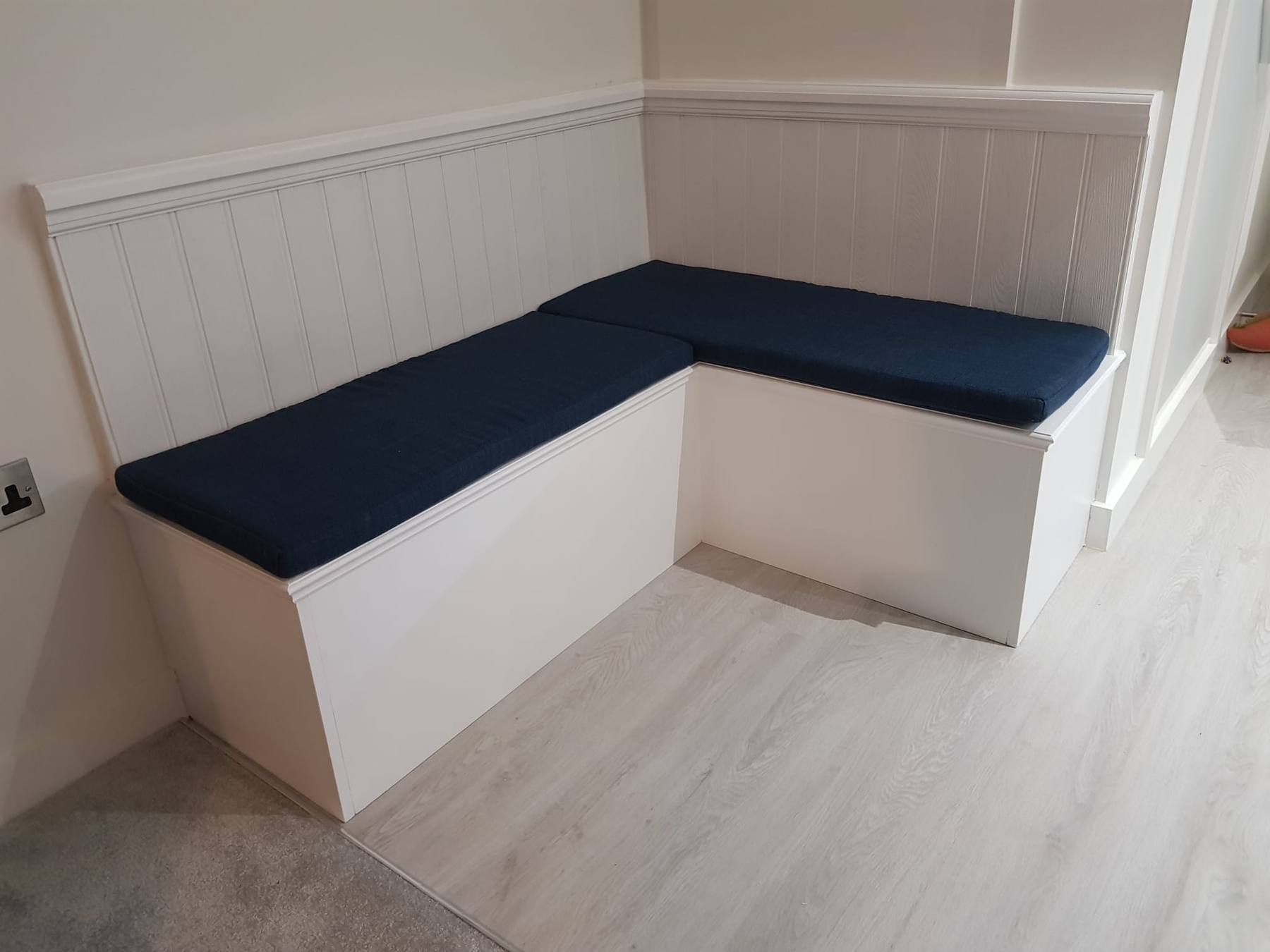 L-shaped banquette bench with panelled back and lift-up storage