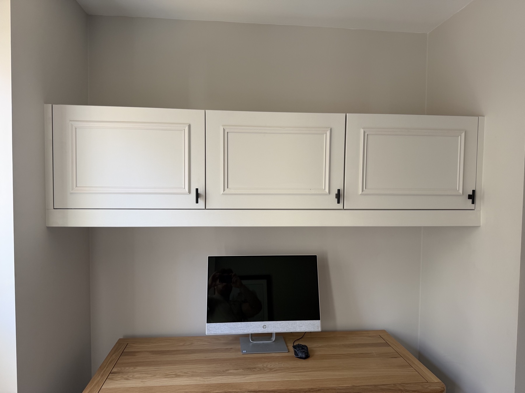 Wall-mounted cabinet with Victorian beading above a desk